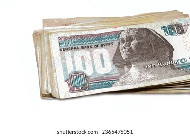 Stack of Egyptian currency of 100 EGP LE one hundred Egyptian pound bills, spending, giving and using money concept, paying and buying using banknotes with Sultan Hassan mosque and the Sphinx - Shutterstock ID 2365476051