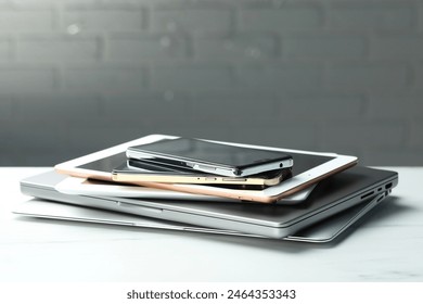 Stack of electronic devices on white table, closeup. Space for text