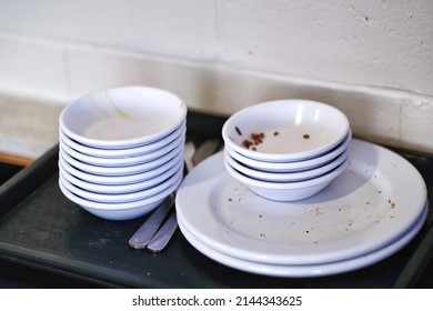 Stack Empty And Dirty Dishes With Food Leftovers Remnants On Tray At Restaurant Or Food Court.