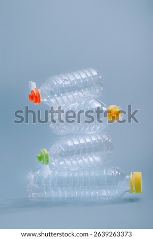 Stack of empty plastic bottles on a blue background, symbolizing plastic waste and environmental pollution.