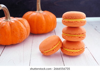 Stack of fall pumpkin spice French macarons. Side view close up scene against a white and black background.