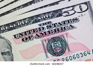 A stack of fifty 50 dollar bills fanned out on a white background