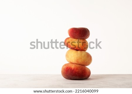 Stack of Fig peaches on the table, side view. Flat donut peaches. Ripe fruits.