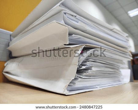 Stack of files, stack of papers, stack of thick files.