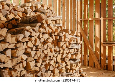 Stack of firewood. Wooden shed for storing firewood indoors. Firewood pile to be used as fuel for heating in fireplaces and furnaces. Wooden wall from pile of firewood stacked in an old farm shed.  - Shutterstock ID 2205174473