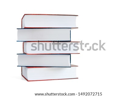 Stack of five books with blue and red covers isolated on a white background. Side view. Copy space