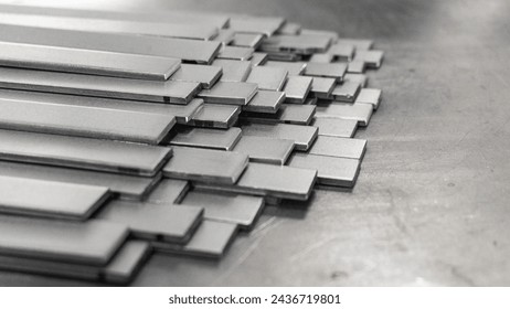 Stack of flat stainless steel bars for background.