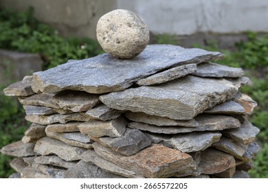 stack of flat stones and a round stone on top, natural, balanced, construction, cairn, rock pile, meditation, zen, harmony, stability, abstract, texture, pattern,
