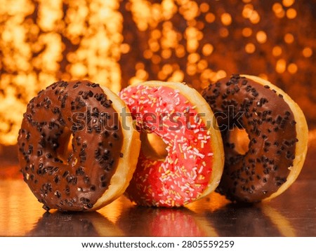 Stack of flattering tasty doughnuts on reflective surface and soft bokeh background. Fine bakery product and delicious dessert. Good for food blogs and industry.