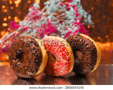Stack of flattering tasty doughnuts on reflective surface and soft bokeh background. Fine bakery product and delicious dessert. Good for food blogs and industry.