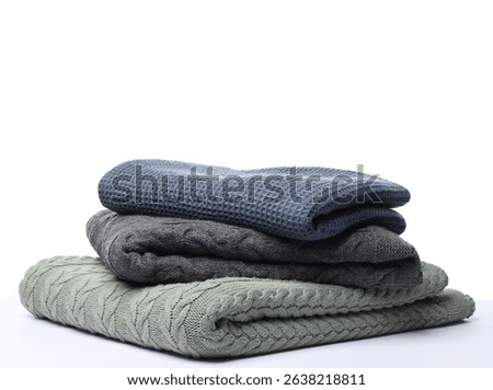 Stack of folded blankets on white background