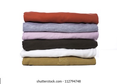 A Stack Of Folded Shirts Against A White Background.