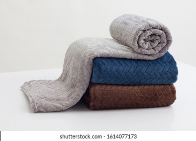 Stack Of Folded Soft Blankets On The White Table