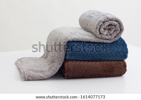stack of folded soft blankets on the white table