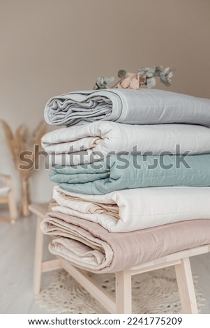 Stack of folded warm blankets with different design patterns. cotton blankets. Close up view of hypoallergenic Cotton bedding.