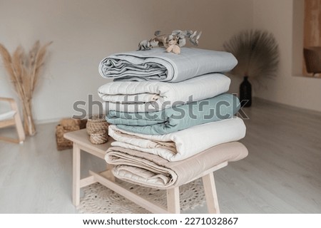 Stack of folded warm blankets with different design patterns. cotton blankets. Close up view of hypoallergenic Cotton bedding.