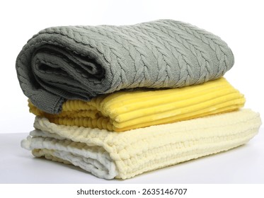 Stack of folded woolen blankets on white background