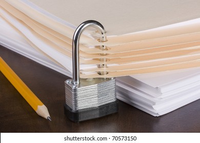 Stack of folders closed by a metal lock.