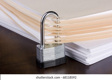Stack of folders closed with a metal lock.