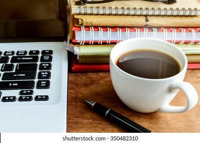 Stack Of Folders And Documents On Office Desk With Coffee And Laptop