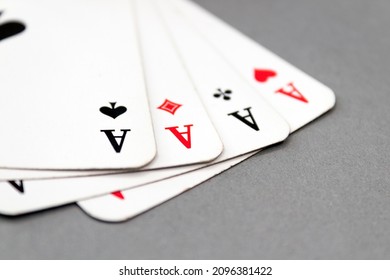 A stack of four aces isolated on a grey background