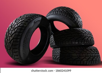 Stack of four new red tyres for winter car on blue background