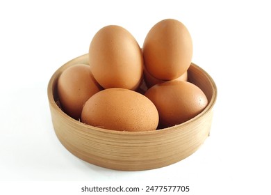 Stack of fresh chicken egg in basket wicker bamboo. Isolated on white background with copy space. Suitable for editing and used for food and nutrition advertising. 