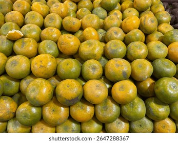 A stack of fresh Medan oranges arranged neatly on a fruit store shelf. Traditional Indonesian citrus fruit known for its sweet and tangy flavor. Healthy organic produce rich in vitamin C and antiox