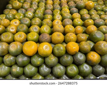 A stack of fresh Medan oranges arranged neatly on a fruit store shelf. Traditional Indonesian citrus fruit known for its sweet and tangy flavor. Healthy organic produce rich in vitamin C and antiox