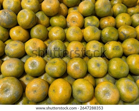 A stack of fresh Medan oranges arranged neatly on a fruit store shelf. Traditional Indonesian citrus fruit known for its sweet and tangy flavor. Healthy organic produce rich in vitamin C and antiox