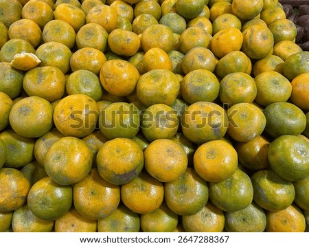 A stack of fresh Medan oranges arranged neatly on a fruit store shelf. Traditional Indonesian citrus fruit known for its sweet and tangy flavor. Healthy organic produce rich in vitamin C and antiox