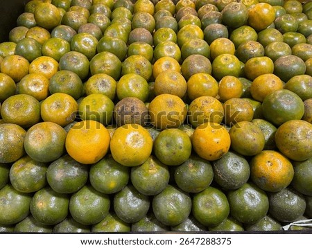 A stack of fresh Medan oranges arranged neatly on a fruit store shelf. Traditional Indonesian citrus fruit known for its sweet and tangy flavor. Healthy organic produce rich in vitamin C and antiox