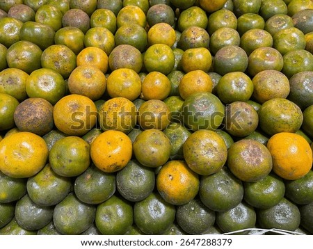 A stack of fresh Medan oranges arranged neatly on a fruit store shelf. Traditional Indonesian citrus fruit known for its sweet and tangy flavor. Healthy organic produce rich in vitamin C and antiox