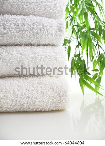 Stack of fresh white towels with blurred bamboo background