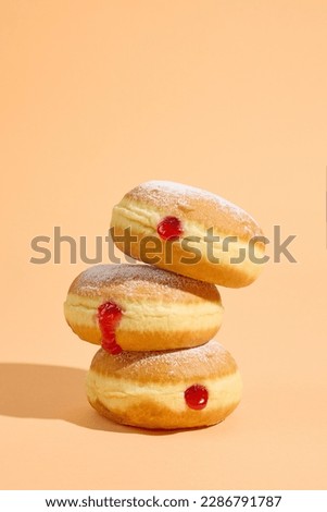 stack of freshly baked jelly donuts on orange background