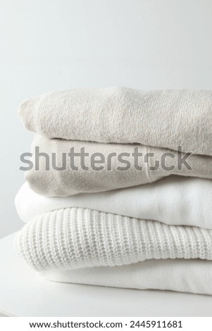 A stack of freshly washed, neatly folded clothing on a wooden table
