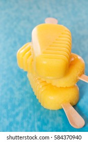 Stack of  fruit ice lollies on a blue surface. Macro, very shallow depth of field