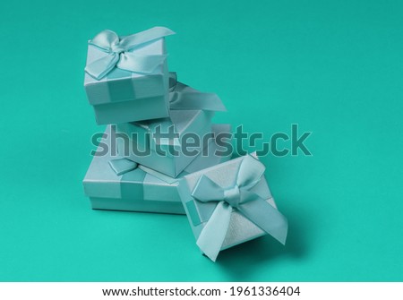 Stack of gift boxes with bows on blue studio background. Composition for christmas, birthday or wedding.