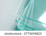 Stack of glass sheets on light background, closeup. Space for text
