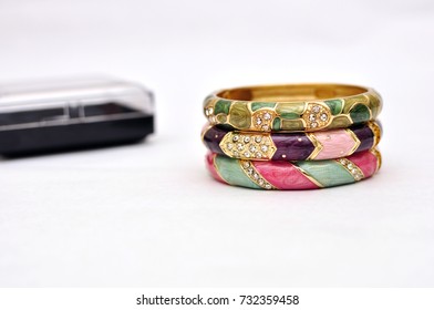 Stack of gold bangle with vivid color and jewelry box isolated on white background