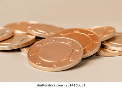 Stack of gold casino chips with a subtle texture on a light brown surface. Gambling and betting concept and symbol