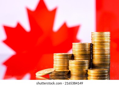 A stack of gold coins on the background of the flag of Canada. Country economy concept