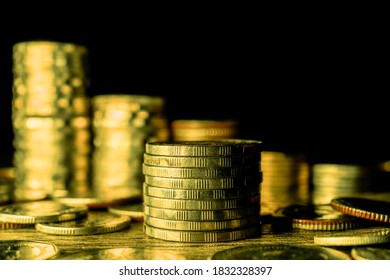Stack of gold coins on dark background.