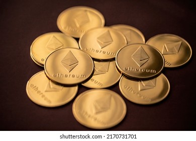 Stack Of Golden Ether Coins Or Ethereum Coins Close Up On Dark Red Background Depicting Cryptocurrency And Digital Money