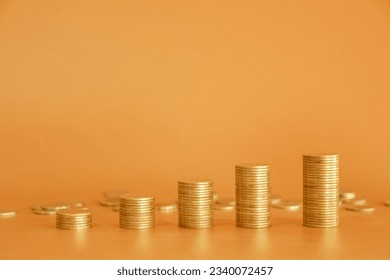 Stack of golden money coin on orange background with copy space. Minimal business and financial background concept. - Powered by Shutterstock