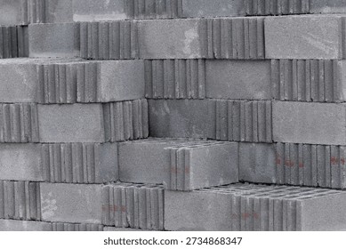 A stack of gray bricks with red numbers on them. The bricks are piled on top of each other, creating a wall-like structure