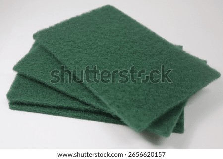 A stack of green abrasive hand pads. Can be used for light-duty cleaning and polishing to heavy-duty jobs like paint, rust, and corrosion removal as well for prepping surfaces before painting. 