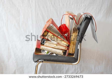 Stack of grungy messy ring binders,flie folders on an office chair. Business concept, bureaucracy, lack of staff,high sickness rate,free copy space.