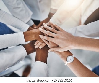 Stack of hands, collaboration and group of doctors in hospital with unity, healthcare or support. Huddle, top view and team of medical employees with celebration for treatment success in clinic.