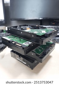 A stack of hard drives with exposed circuit boards.